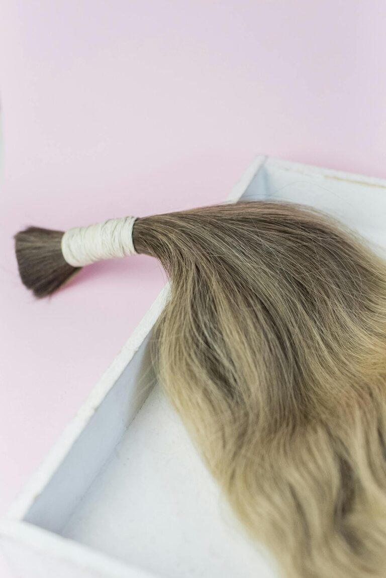 A detailed hair extension on a pink background, ideal for beauty concepts.